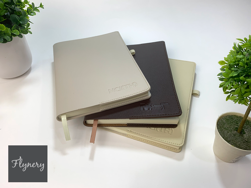 สมุดโน๊ตแบบสอดปกปีกสองข้าง หนังพีวีซีแบบหนาด้านหลังบุกำมะหยี่ เย็บริมรอบเล่ม ของขวัญธุรกิจสำหรับปีใหม่นี้ มีหนังหลากสีให้เลือก พร้อมริบบิ้นสีคั่นหน้ากระดาษ 